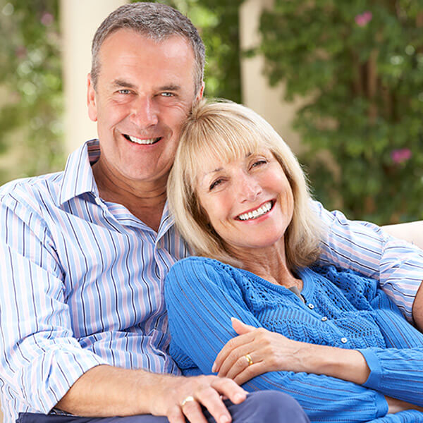 Mature couple sited in the sofa smiling